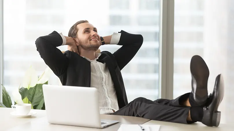 An image of a man in an office chair daydreaming