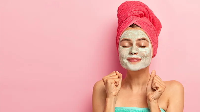 An image of A woman having an eye mask on her face.