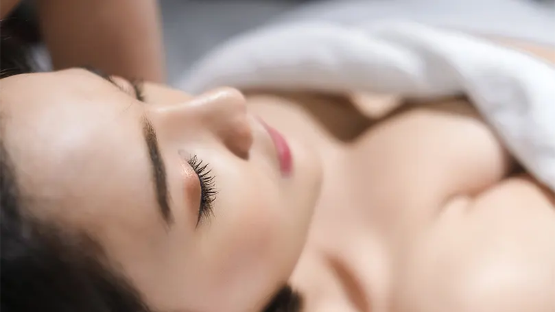 An image of a beautiful asian woman sleeping naked.
