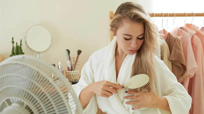 An image of a beautiful woman in front of a fan.