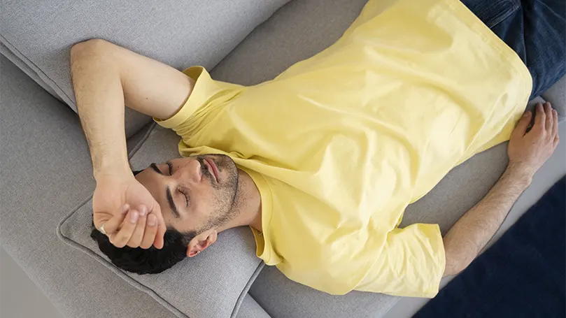 An image of a man in a yellow shirt sleeping without snoring