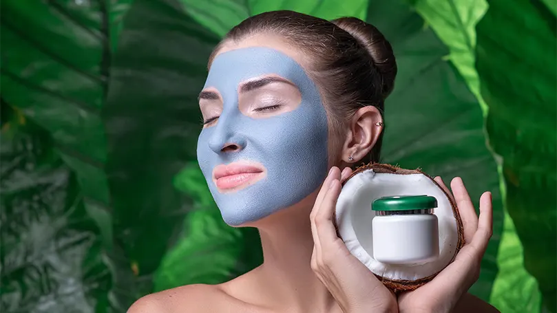 An image of a woman having coconut eye mask on her face.