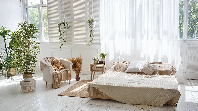 An image of a bedroom with plenty of natural light and greenery