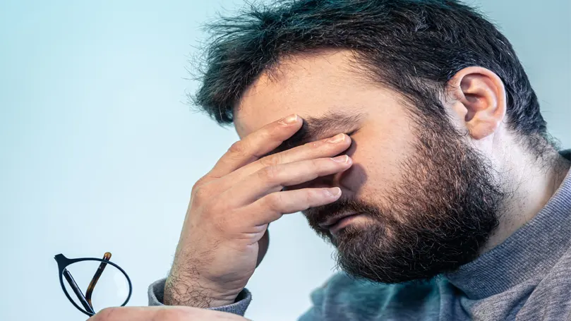 An image of a man having an eye fatigue.