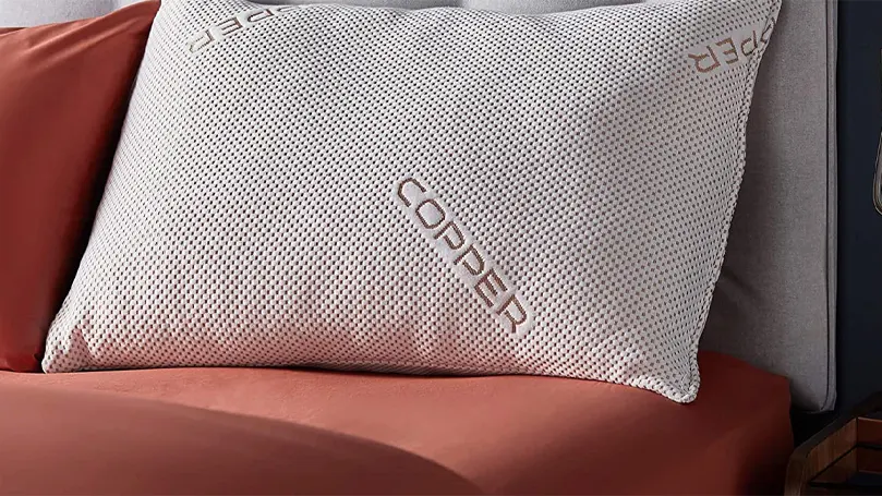 An image of Silentnight Wellbeing Copper Infused pillow close up on a bed.