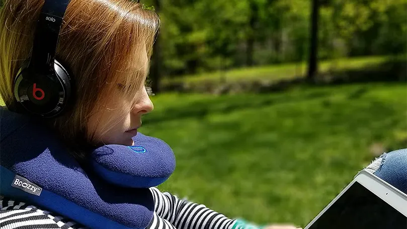 An image of a woman enojying outdoor with Bcozzy Chin Supporting Travel pillow.