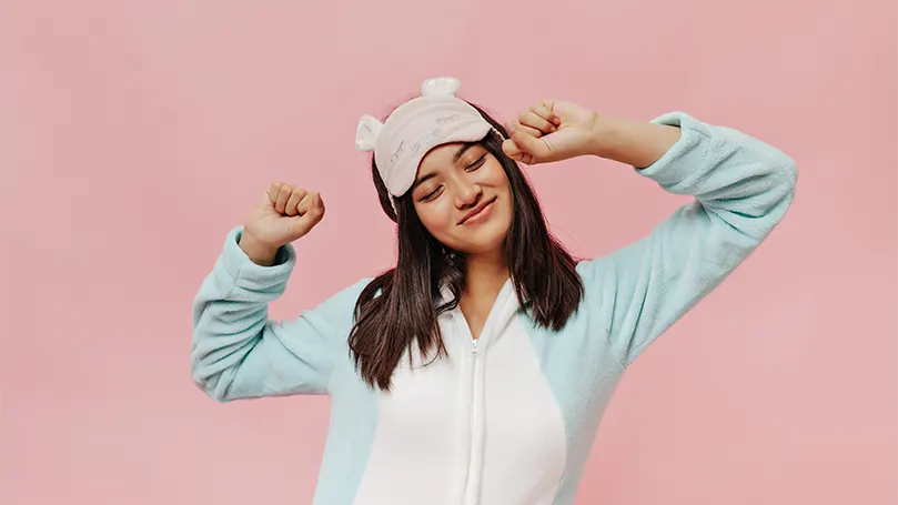 An image of a young asian woman in a soft pyjama with sleep mask.