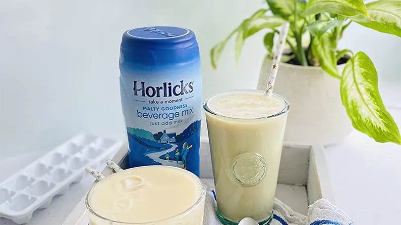 Horlicks in a glass with a straw.