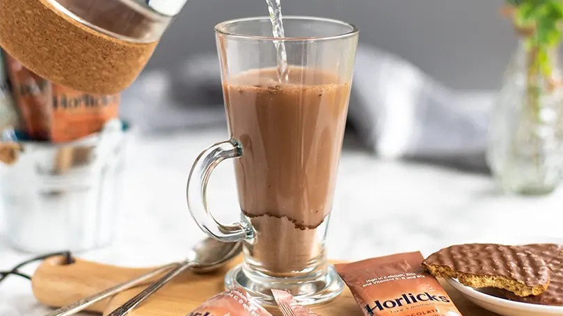 Pouring horlicks in a glass.