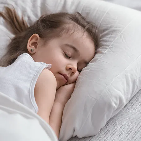 A little girl sleeping on a hypoallergenic pillow