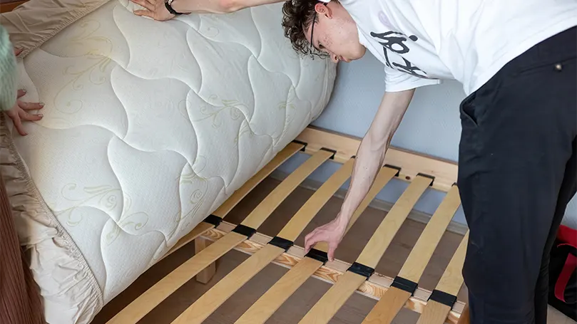 An image of a guy fixing slats.