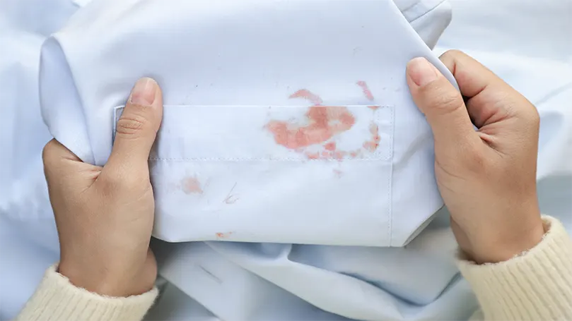 a woman holding a sheet in hands heet with blood stain.