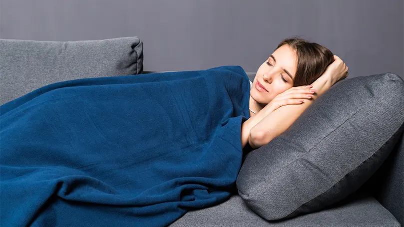 An image of a woman under a weighted blanket
