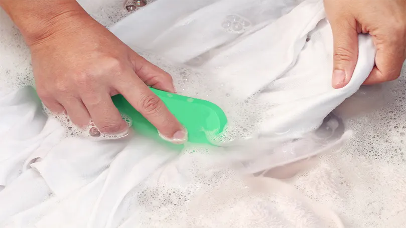 a woman hand washing sheets in cold water.