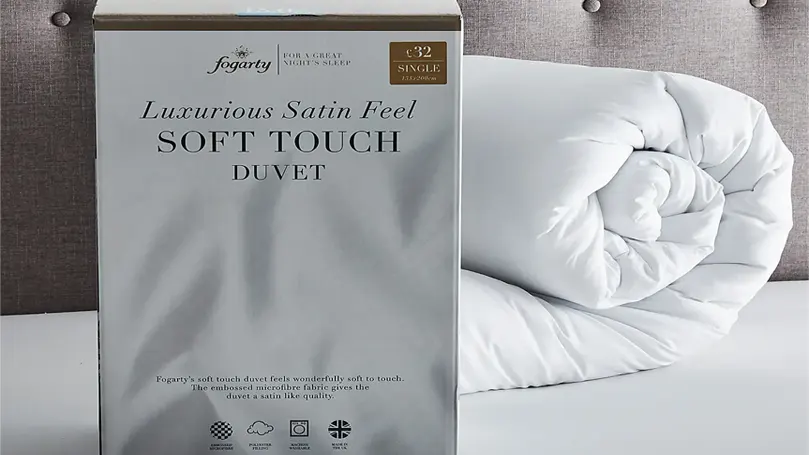 An image of Fogarty Soft Touch 15 Tog duvet on bed with package.