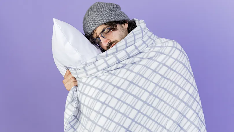An image of a man covered with a duvet.