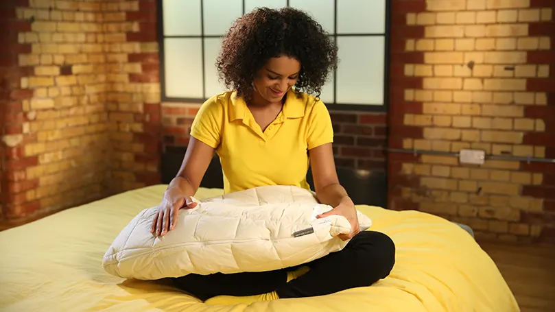 our reviewer testing the Woolroom V-Shaped Washable Wool Pillow