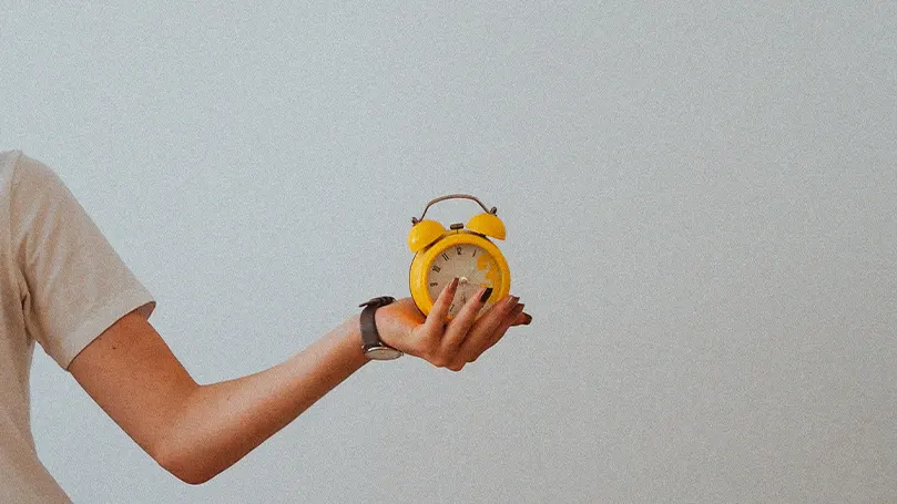 An image of a person holding up a clock