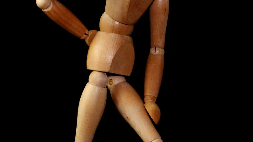 a wooden doll simulating a position with sciatica pain