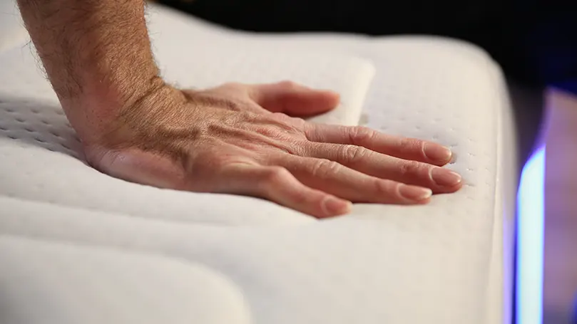 A hand of our reviewer pressing on a mattress