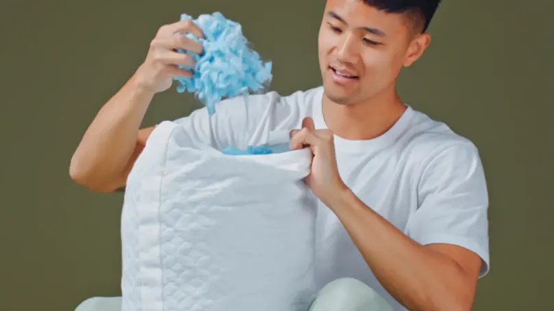 An image of a person taking out the shredded memory foam filling from an Aeyla FOAMO pillow