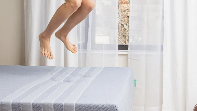 An image of a person jumping on a bed