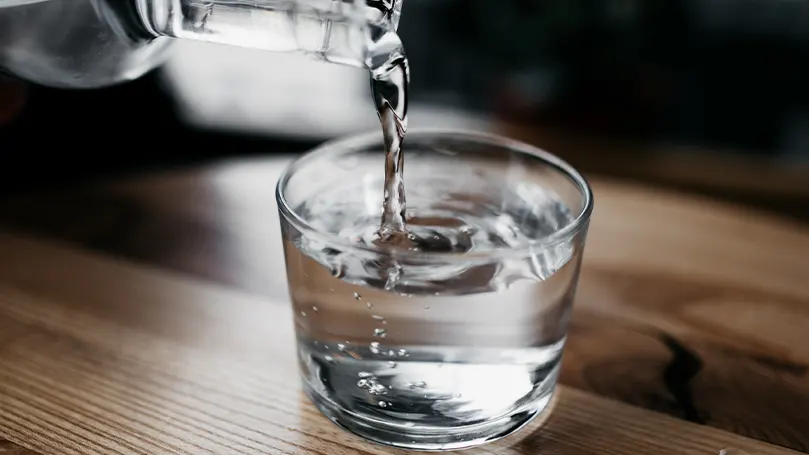 An image of a person pouring water into a cup