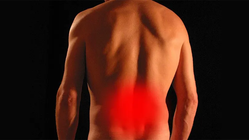 The back of a person with red over their lower back.