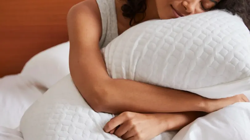 An image of a woman gripping a pillow