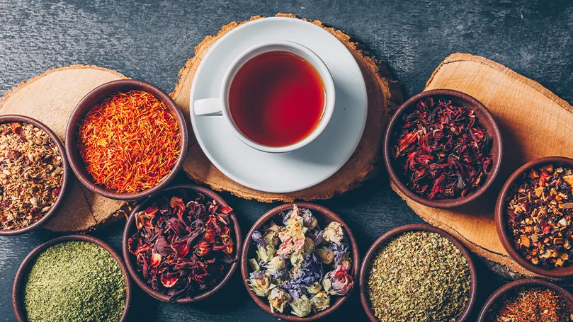 An image of herbal tea in a cup surrounded by other healthy teas