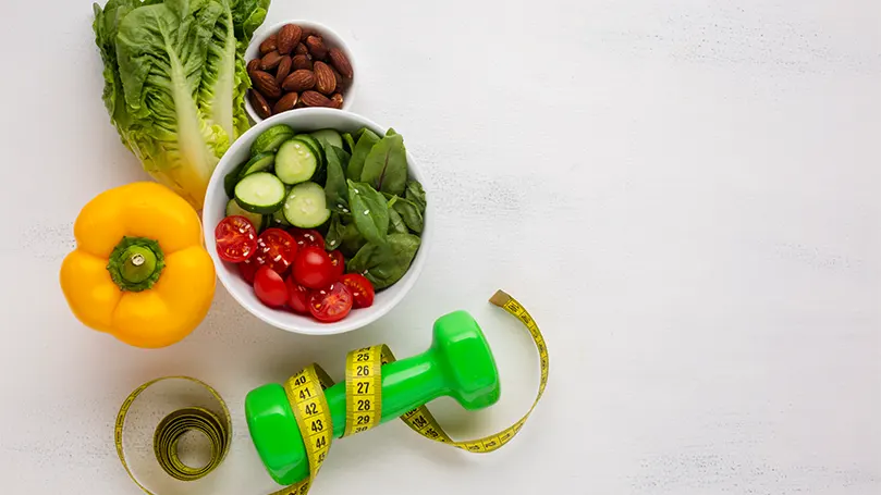 An image of healthy food and a weight used for exercise
