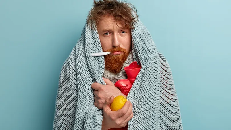 An image of a sick man holding apples.