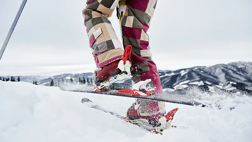 An image a person's legs on skiis.