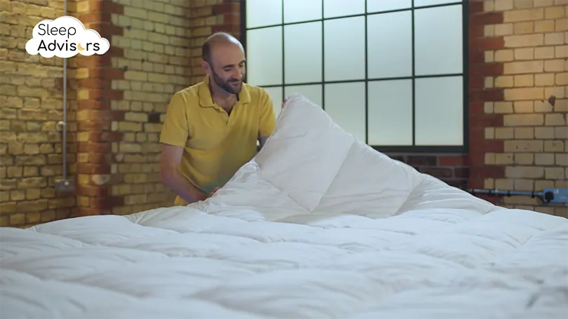 our reviewer putting the Dorma topper on the bed