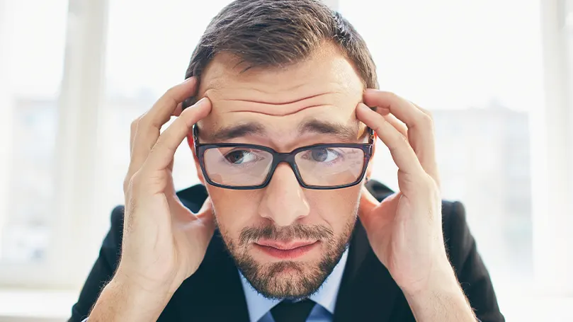 An image of a worried man with glasses