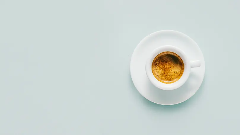 An image of a cup of coffee on a white table