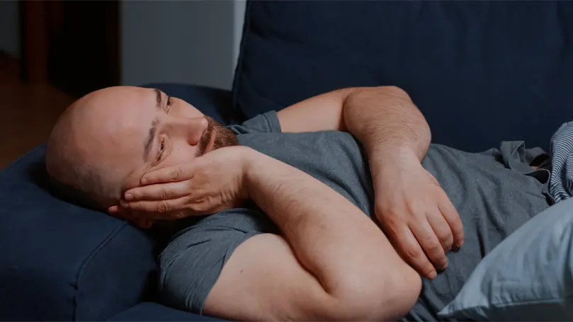 An image of a man in bed worried and unable to sleep