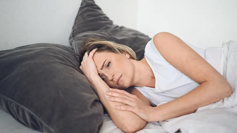 An image of a woman stressed out in bed