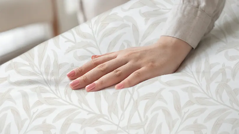 An image of a woman's hand on a sheet.