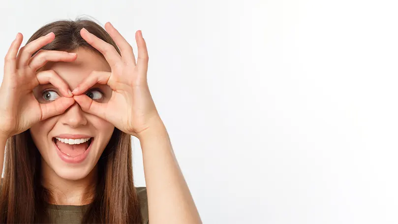 An image of a woman looking through her fingers