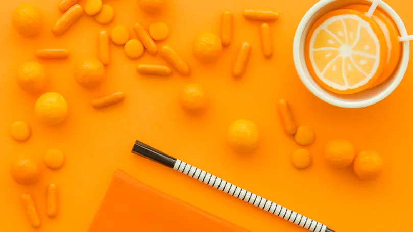 An image of vitamins on an orange background.