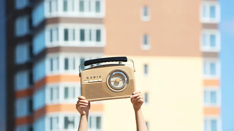 An image of a person holding a radio.