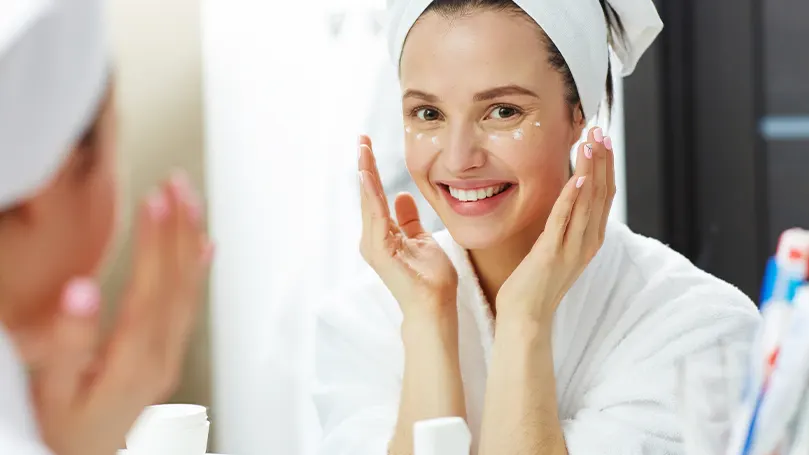 An image of a woman with a towel on her head taking part in a relaxing bedtime routine