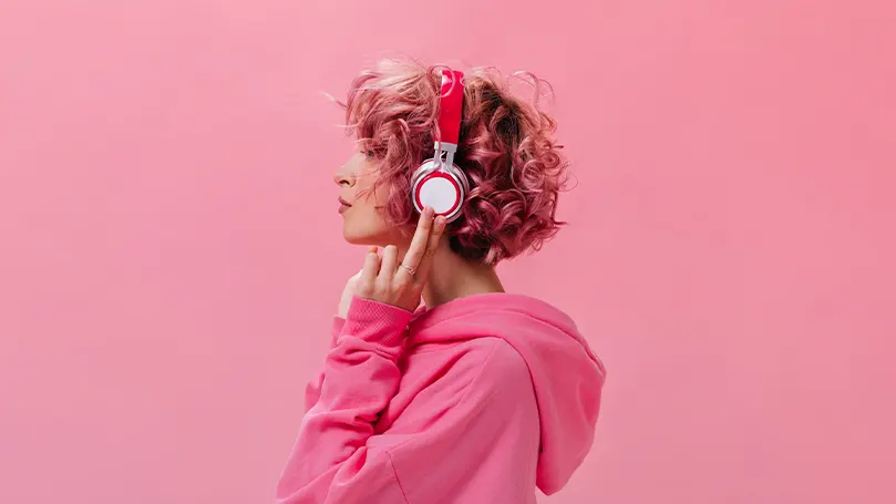 An image of a woman with headphones on listening to music