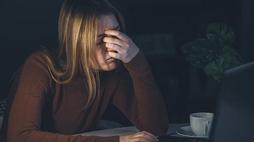 A woman sitting in dark having an anxiety