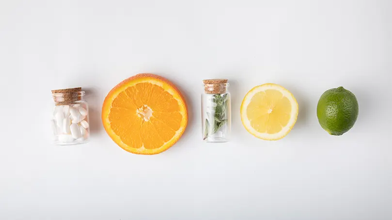 An image of orange slices and herbs in bottles.