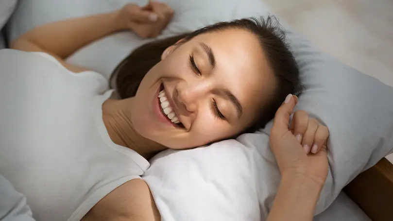 A woman laughing while sleeping.
