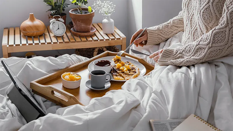 An image of a person eating in bed.