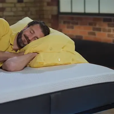 A Sleep Advisor's presenter sleeping on Emma Original mattress.