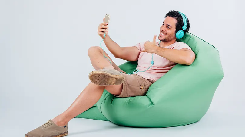 An image of a happy man in a green bean bag chair